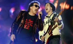 Na koncercie Lady Pank, wokalista w czarnej koszulce z napisem "Pank '82" i narzeczona w białej bluzie grają na gitarze.