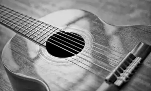 Zbliżenie na gitarę klasyczną. Zastanawiasz się, ile kosztuje dobra gitara? Ten instrument wygląda na wart swojej ceny.