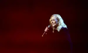 Artystka śpiewa, a jej głos niesie ze sobą zapach róży, tekst utworu unosi się w mroku sceny.