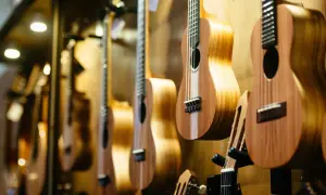 Rząd drewnianych ukulele wiszących na ścianie, z bliska.