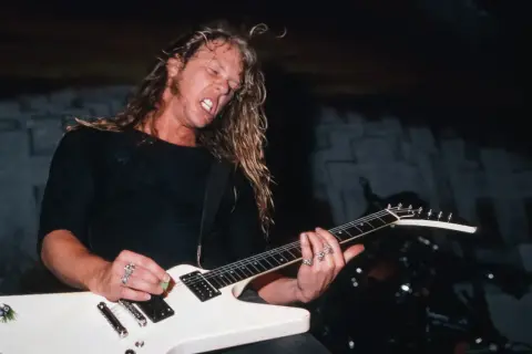 James Hetfield z Metalliki gra na białej gitarze typu Flying V.