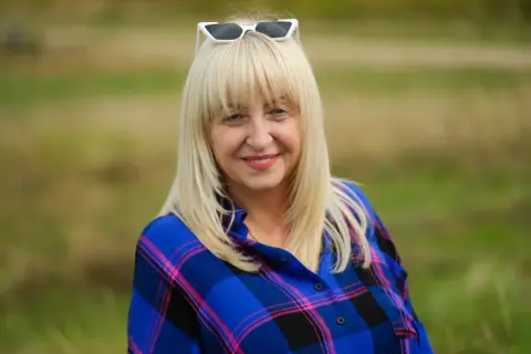 Uśmiechnięta blondynka w kratę, z okularami na głowie. To były piękne dni, pełne słońca i radości.