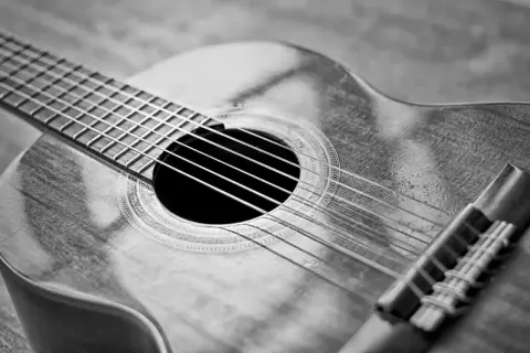 Zbliżenie na gitarę klasyczną. Zastanawiasz się, ile kosztuje dobra gitara? Ten instrument wygląda na wart swojej ceny.