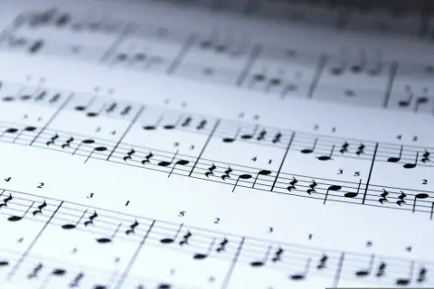 Gdzie w uroczystej cichości nuty układają się w melodię. Delikatne linie pięciolinii i czarne nuty tworzą obraz muzyki.