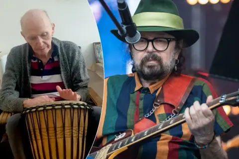 Starszy mężczyzna gra na bębnie, obok muzyk w kapeluszu z gitarą. Może to być perfect kołysanka dla nieznajomej tekst.