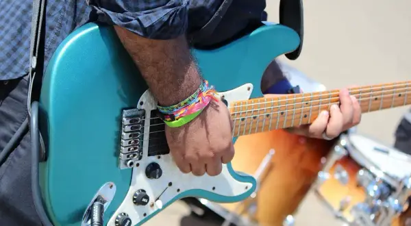 Ręka grającego na gitarze z kolorowymi bransoletkami, nie nie nie, to muzyka!