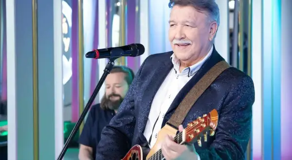 Andrzej Rybiński śpiewa "Nie liczę godzin i lat", grając na gitarze.