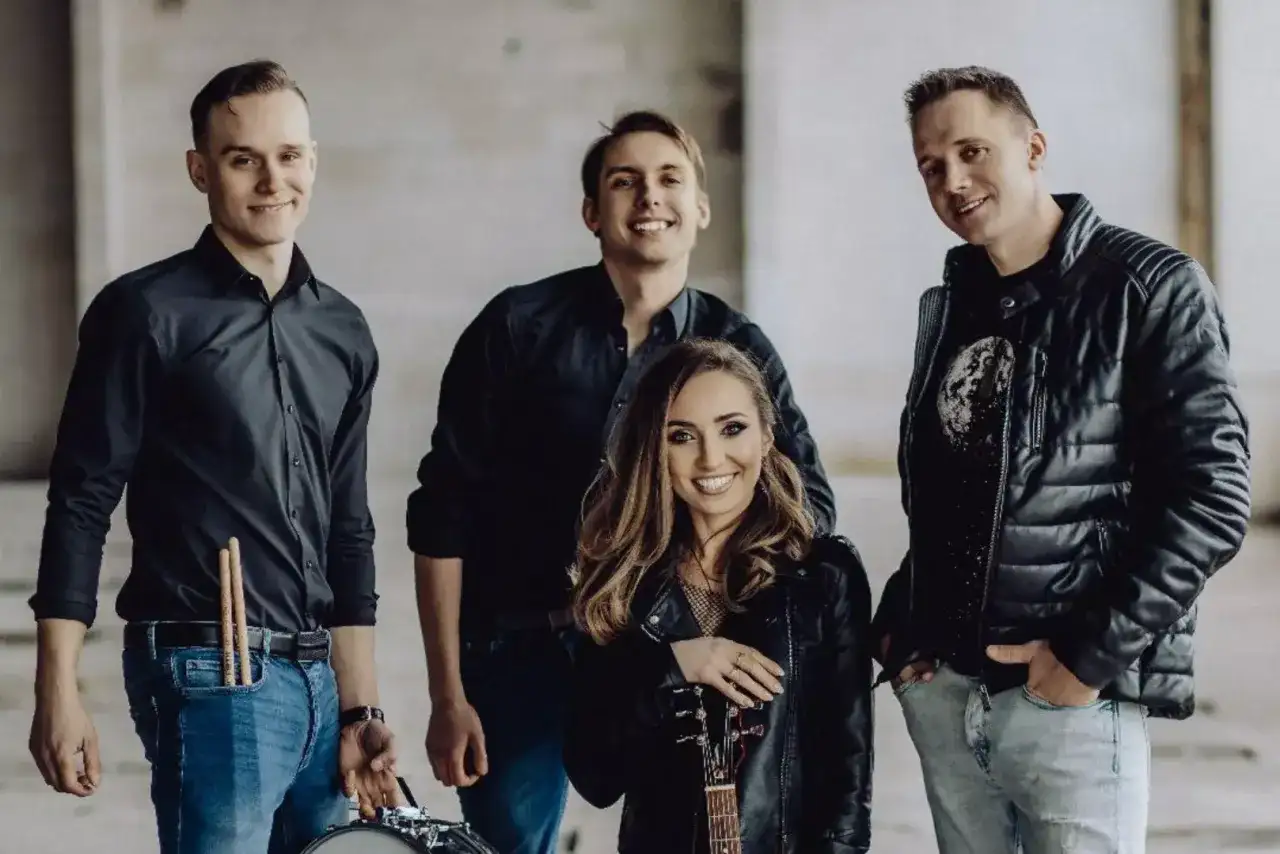 Zespół muzyczny gotowy, by zabierz mnie do gwiazd. Wokalistka z gitarą, perkusista z pałeczkami i dwaj gitarzyści.
