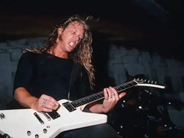 James Hetfield z Metalliki gra na białej gitarze typu Flying V.