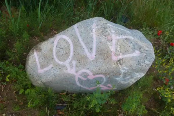 Duży kamień z różowym napisem LOVE i sercem.