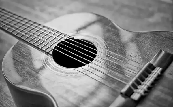 Zbliżenie na gitarę klasyczną. Zastanawiasz się, ile kosztuje dobra gitara? Ten instrument wygląda na wart swojej ceny.