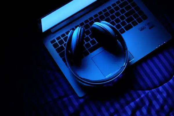 Słuchawki na laptopie w niebieskim świetle. Zastanawiasz się, ile trwa ósemka nuta?