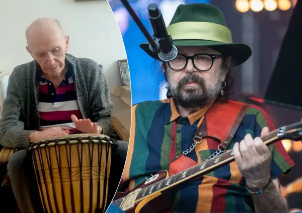 Starszy mężczyzna gra na bębnie, obok muzyk w kapeluszu z gitarą. Może to być perfect kołysanka dla nieznajomej tekst.