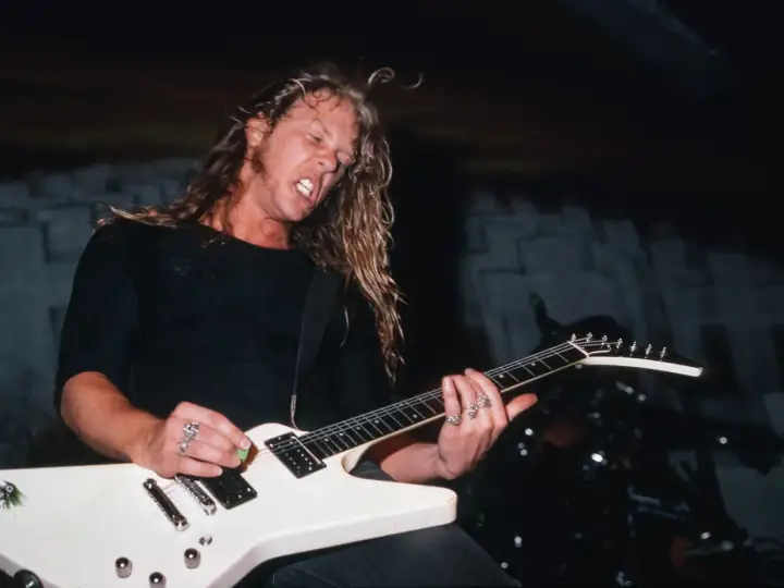 James Hetfield z Metalliki gra na białej gitarze typu Flying V.